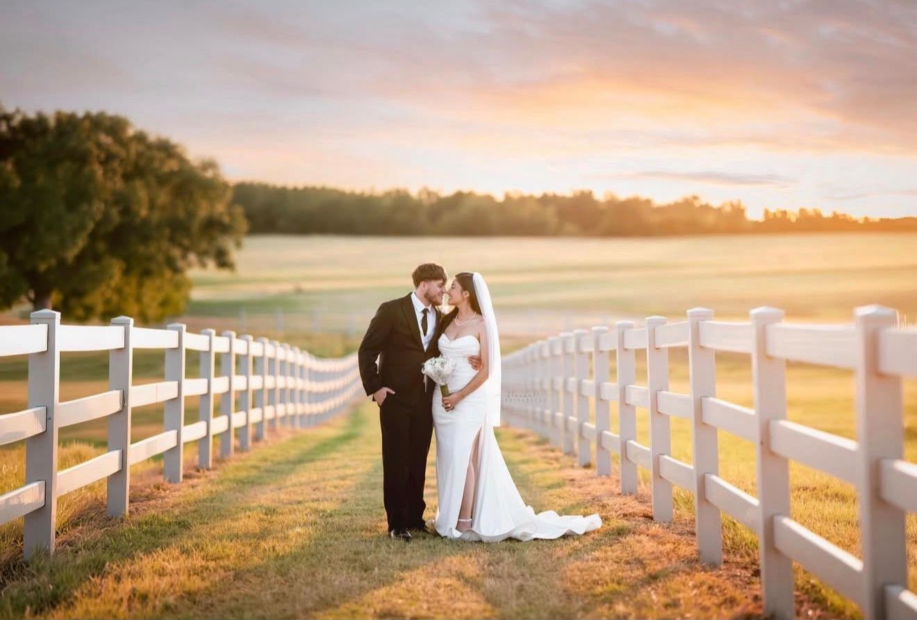 Bride and groom at sunset near a white fence