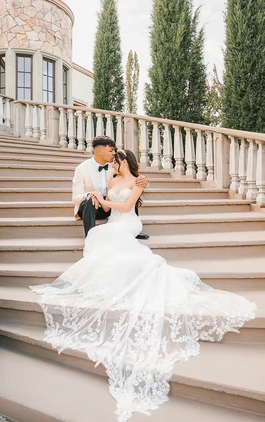 Bride and groom seated together on exterior steps